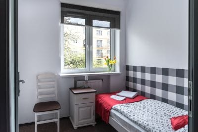 Pokój jednoosobowy na pierwszym piętrze, z  90cm/200cm, wygodnym łóżkiem, dużym ręcznikiem i dywanikiem łazienkowym pod stopy, szafką i oknem z widokiem na ogród