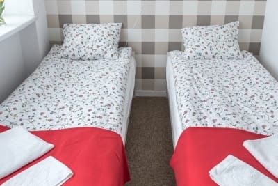 Pokój dwuosobowy z pojedynczymi łózkami 90/200cm, z dużym oknem, lampka do czytania przy łóżku, dużym ręcznikiem, dywanikiem łazienkowym
