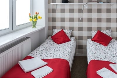 Pokój dwuosobowy z pojedynczymi łózkami 90/200cm, z dużym oknem, lampka do czytania przy łóżku, dużym ręcznikiem, dywanikiem łazienkowym